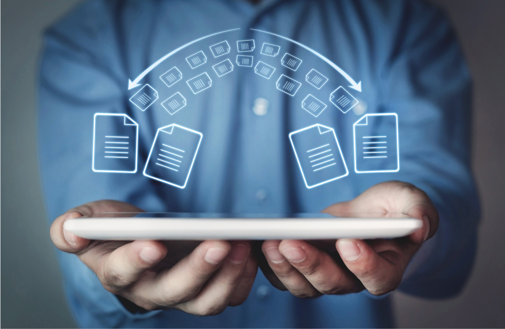 a person holding a table with both hands. Floating above the tablet are icons of files moving from one side the to other and vice versa