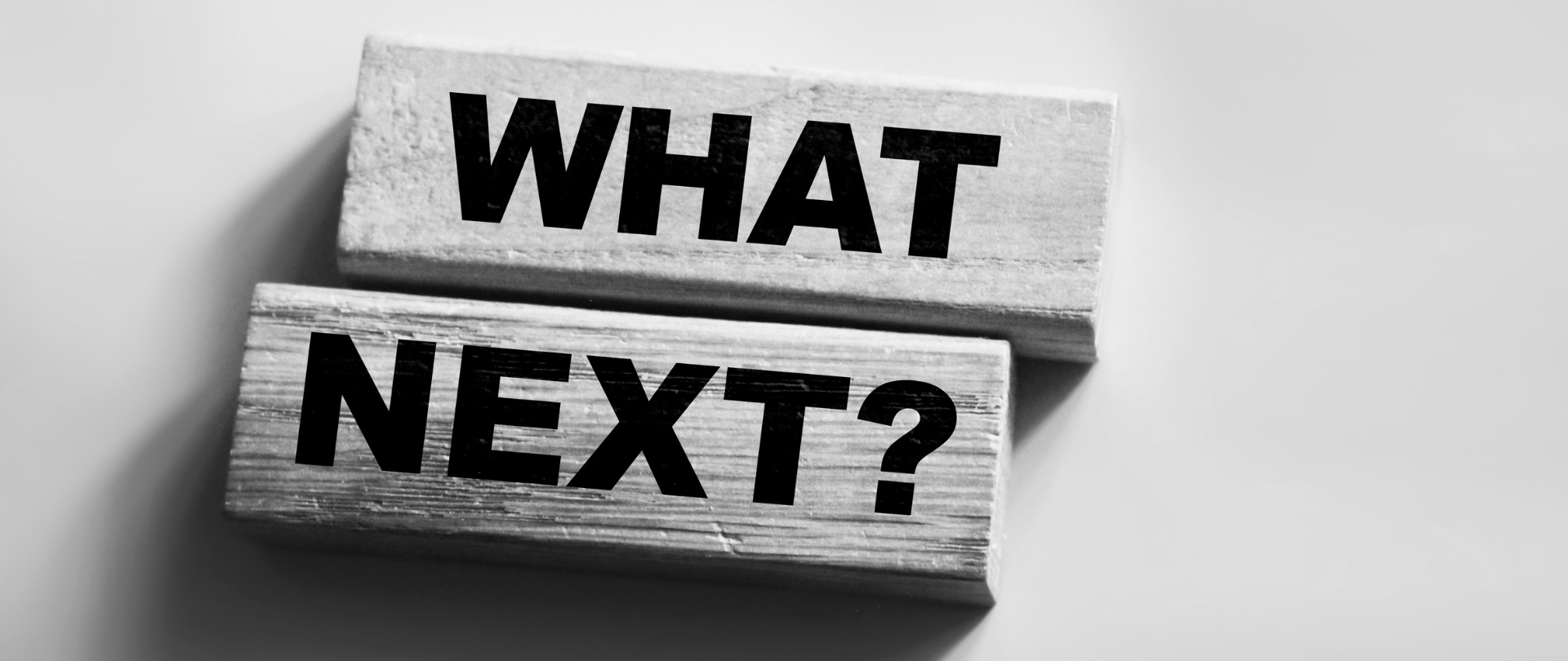 on a grey background two pieces of grey wood with each of them having a word written